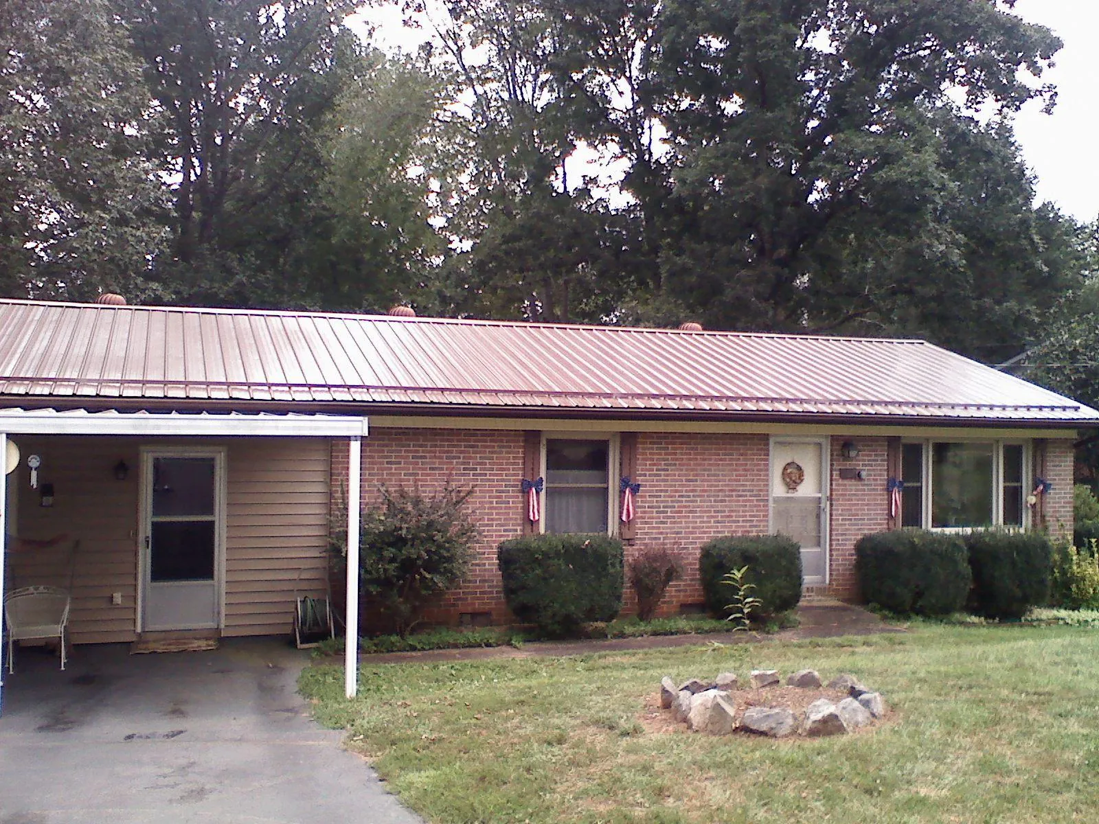 Bronze metal roof and carport on a brick ranch home — Roof Repair work by our crew in Denair