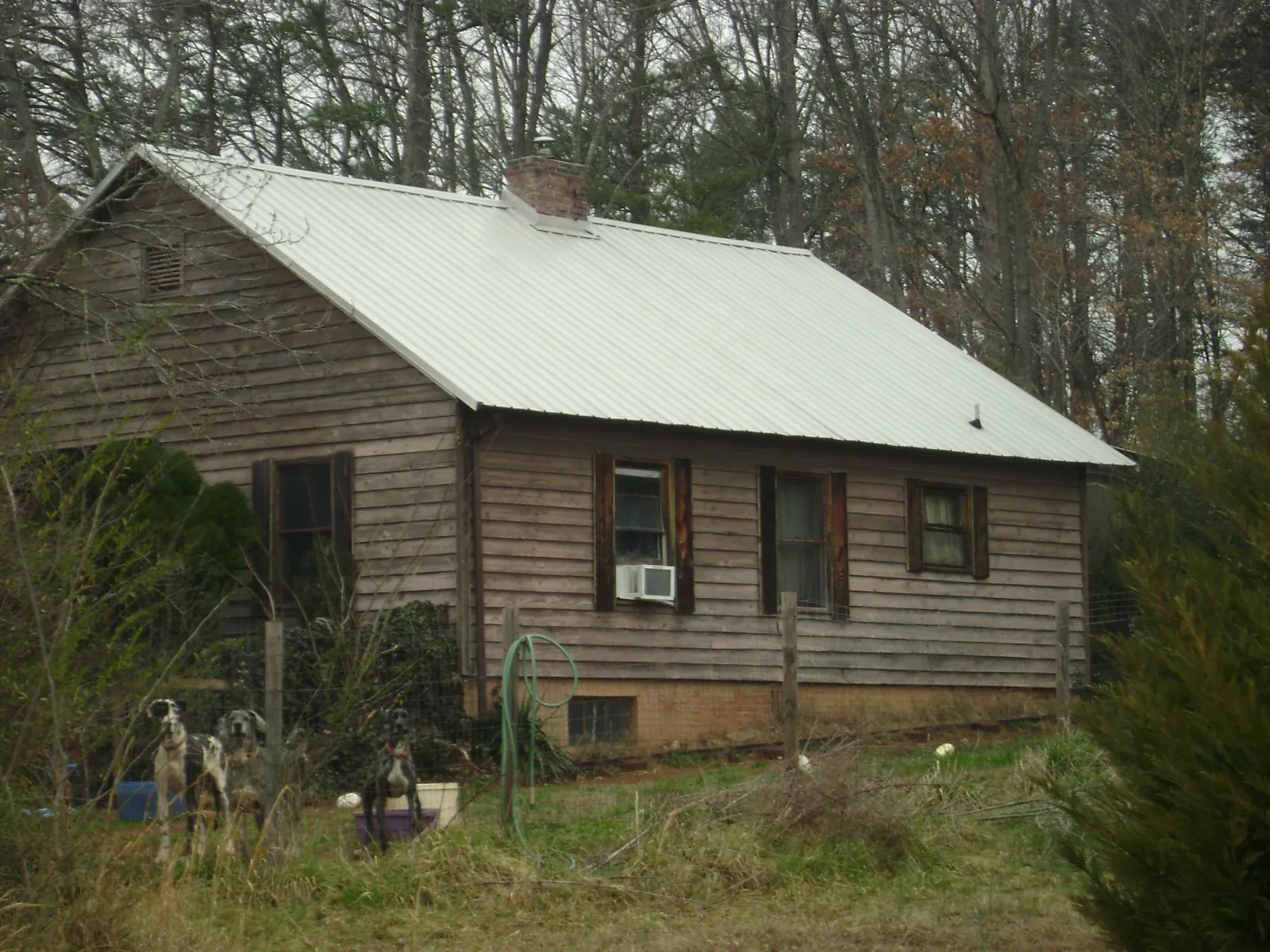White metal roof on an old wood sided farmhouse, from a Metal Roof Installation job in Denair